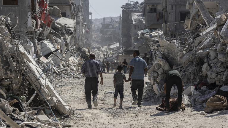 Palästinenser laufen durch zerbombte Viertel in Gaza-Stadt am 16. Oktober 2025.