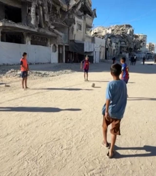 In Gaza kicken Jungs zwischen Trümmern.