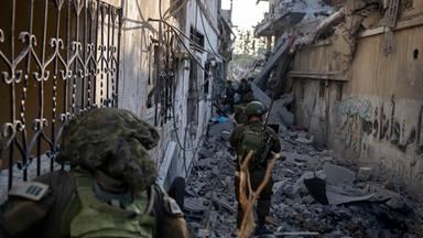 Israelische Soldaten laufen durch Trümmer