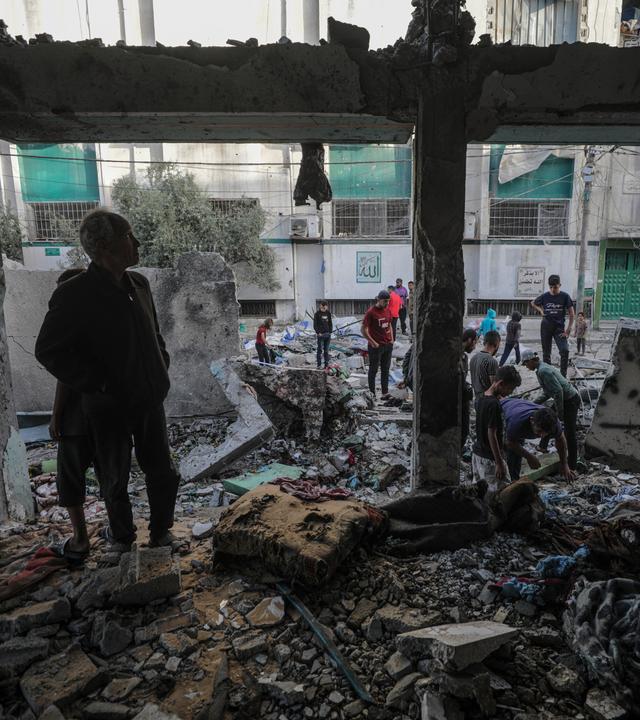Binnenvertriebene Palästinenser untersuchen die Trümmer der Al-Jerjawi-Schule nach einem israelischen Luftangriff im Stadtteil Al Daraj in Gaza-Stadt.