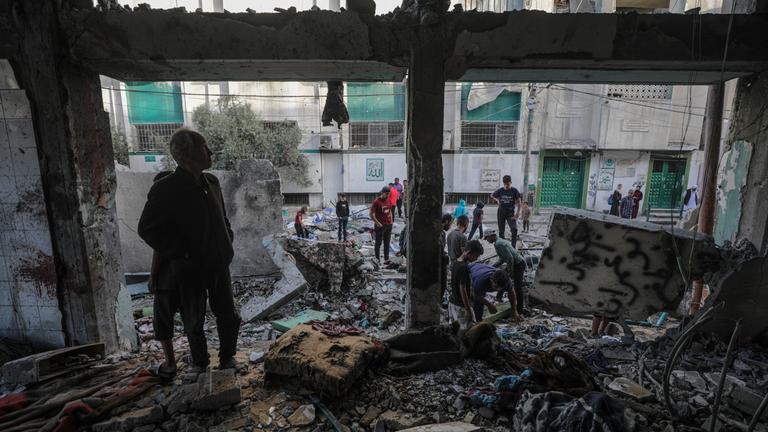 Binnenvertriebene Palästinenser untersuchen die Trümmer der Al-Jerjawi-Schule nach einem israelischen Luftangriff im Stadtteil Al Daraj in Gaza-Stadt.