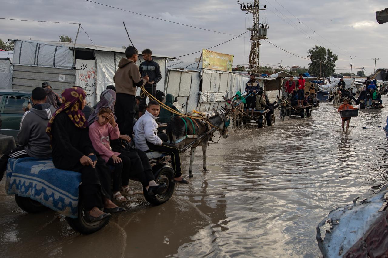 Palästinenser laufen nach starken Regenfällen über eine Straße in Südgaza.
