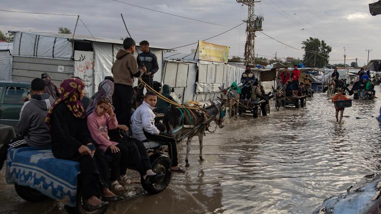 Palästinenser laufen nach starken Regenfällen über eine Straße in Südgaza.