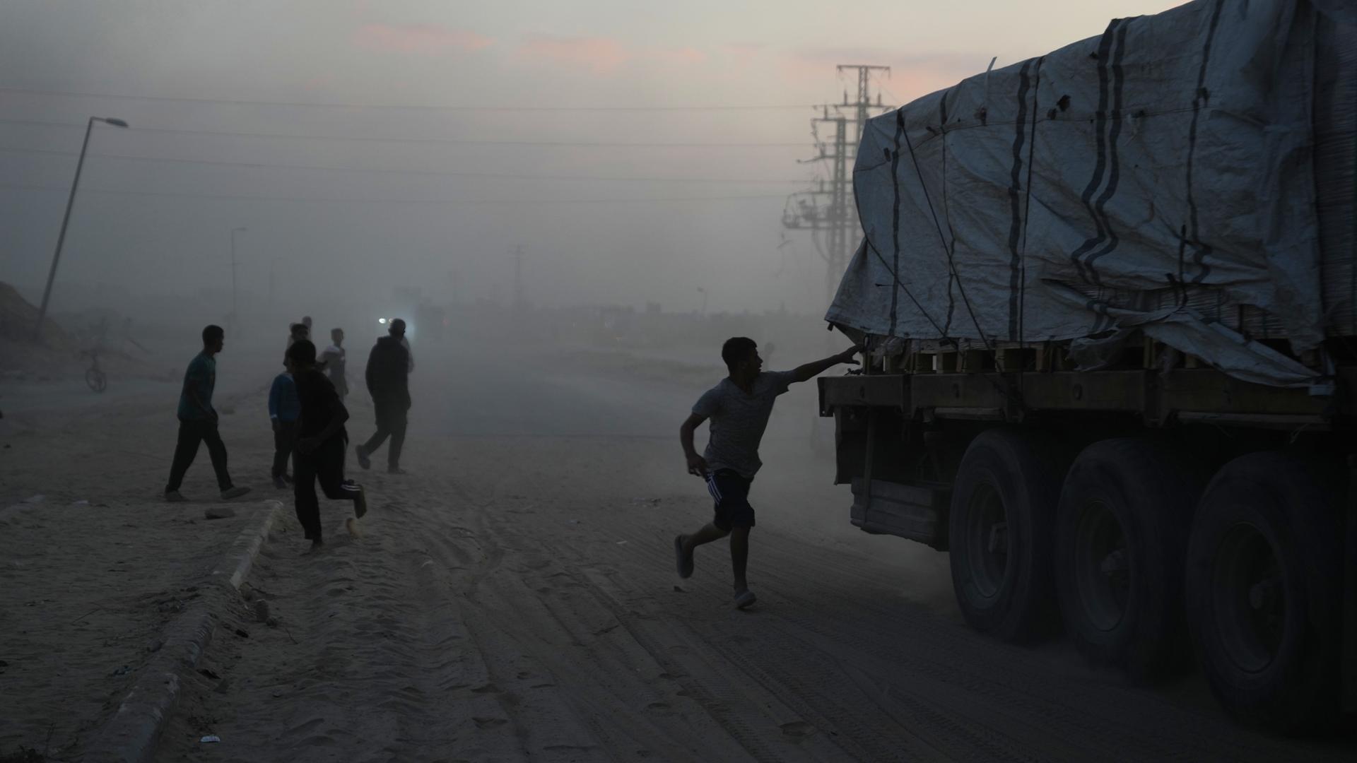 Palästinenser eilen auf Lastwagen mit Hilfsgütern des Welternährungsprogramms (WFP) zu, während diese durch Deir al-Balah im Zentrum des Gazastreifens am 08.11.2025 fahren.