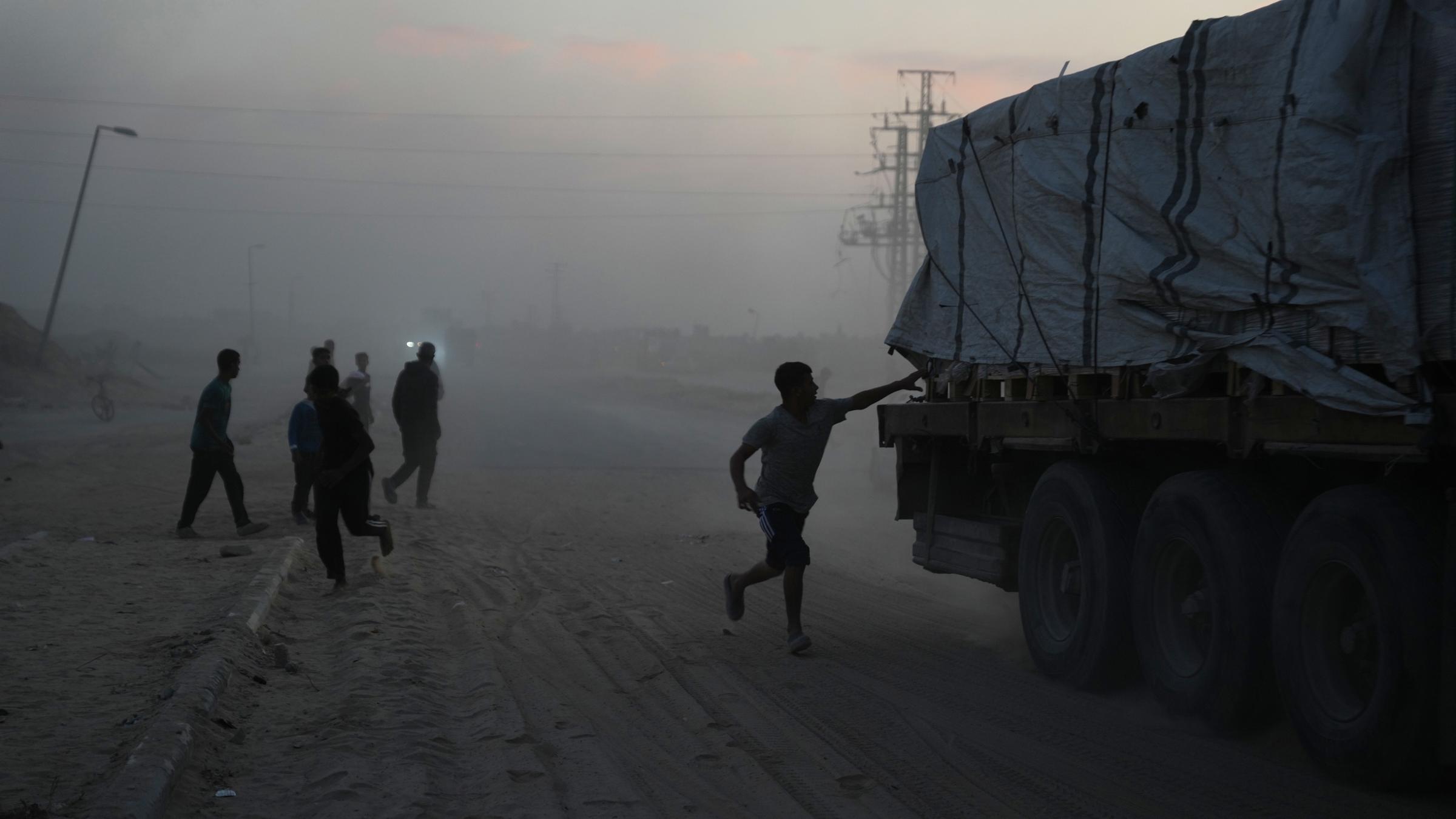 Palästinenser eilen auf Lastwagen mit Hilfsgütern des Welternährungsprogramms (WFP) zu, während diese durch Deir al-Balah im Zentrum des Gazastreifens am 08.11.2025 fahren.