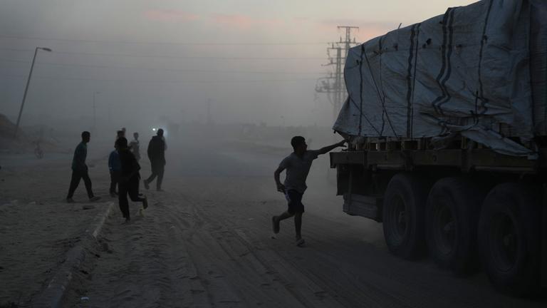 Palästinenser eilen auf Lastwagen mit Hilfsgütern des Welternährungsprogramms (WFP) zu, während diese durch Deir al-Balah im Zentrum des Gazastreifens am 08.11.2025 fahren.