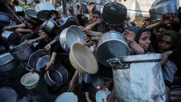Viele Menschen mit Töpfen oder Schüsseln, die sich rangeln um noch etwas zu Essen zu bekommen