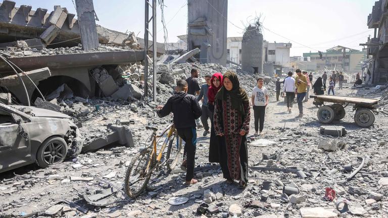 Gazastreifen, Jabalia: Menschen gehen zwischen den Trümmern eines Gebäudes umher