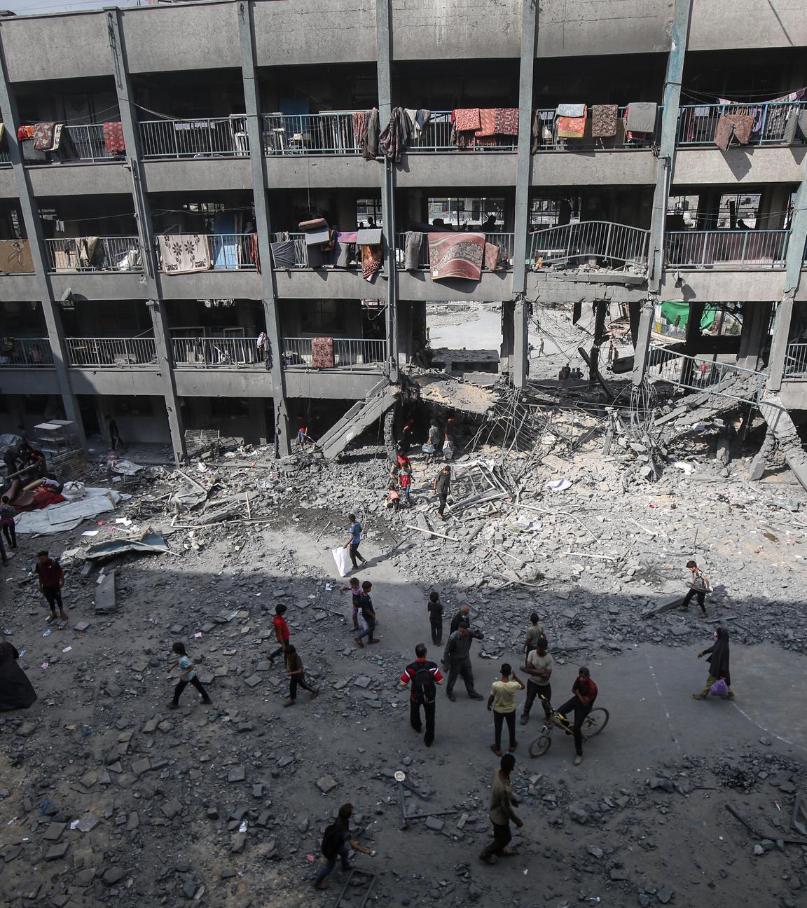 Palästinenser stehen vor einem beschädigten Gebäude nach einem israelischen Angriff in Gaza-Stadt.