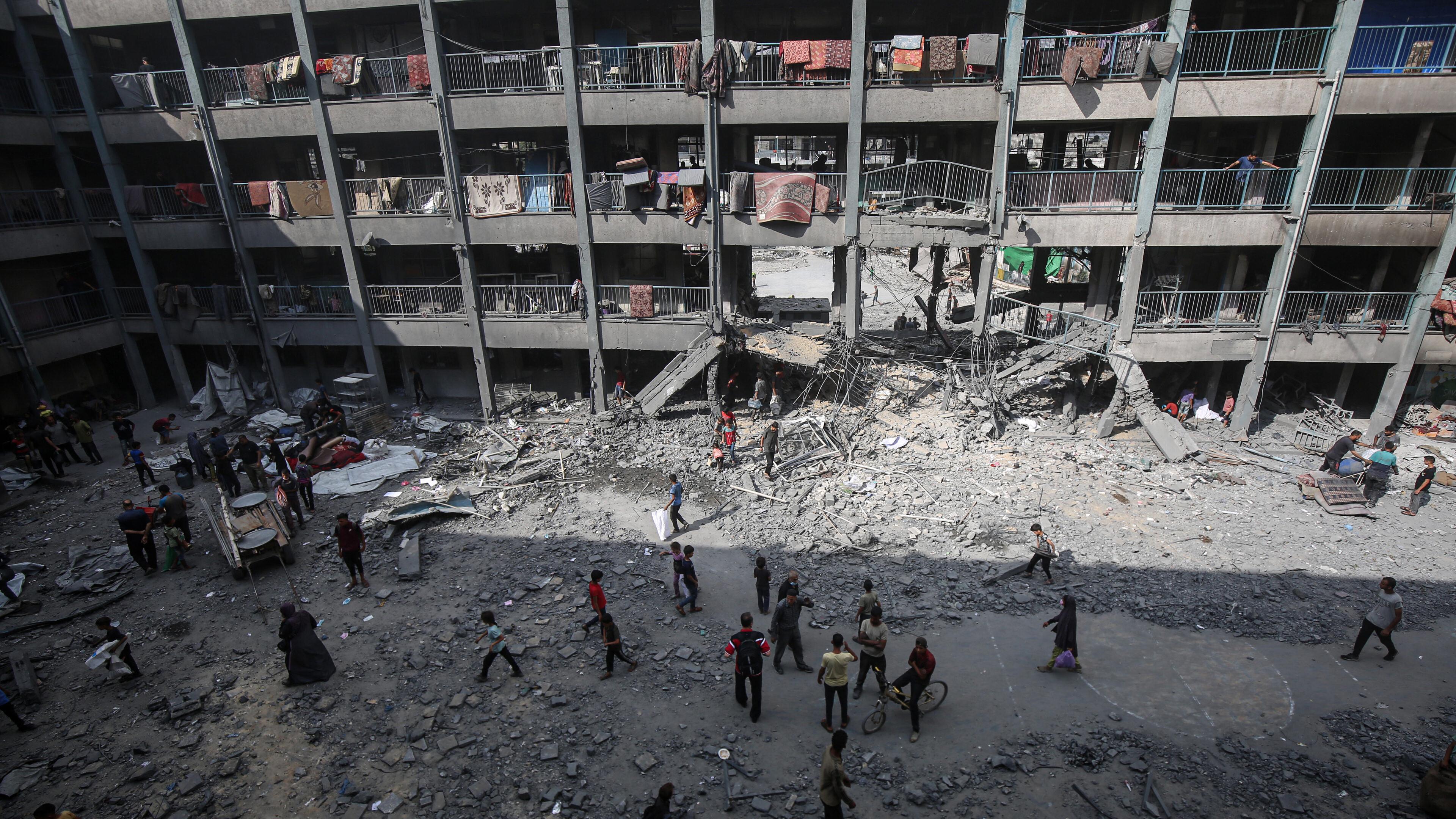 Palästinenser stehen vor einem beschädigten Gebäude nach einem israelischen Angriff in Gaza-Stadt.