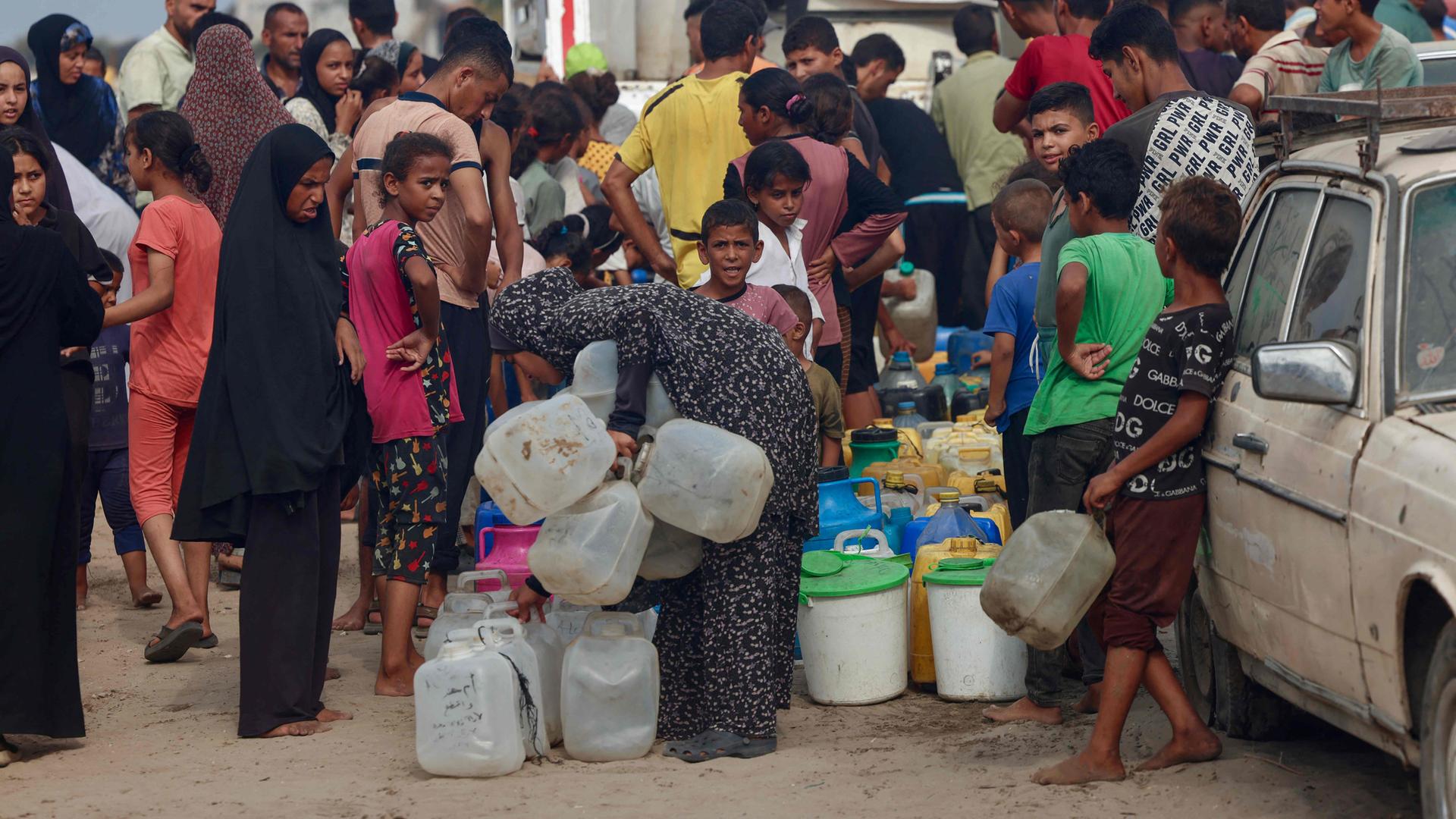 Palästinenser stehen in der sengenden Hitze im Mawasi-Gebiet von Khan Yunis im südlichen Gazastreifen Schlange, um Trinkwasser aufzufüllen