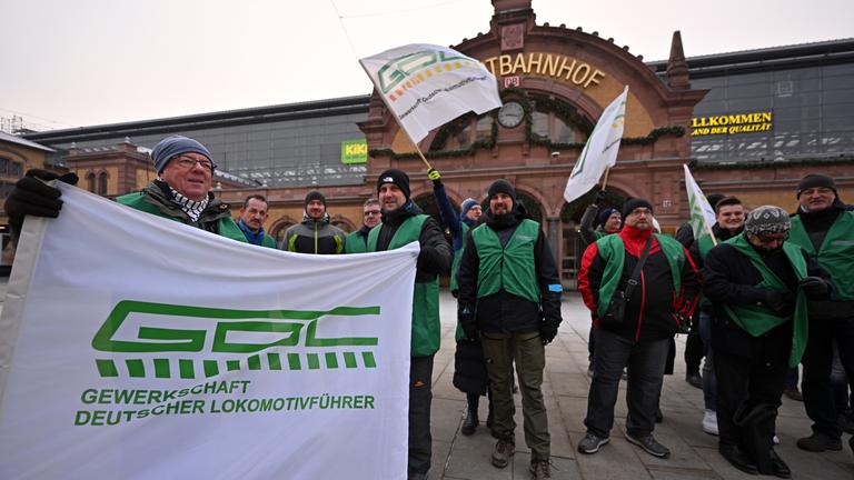 Thüringen, Erfurt: Mitglieder der Lokführergewerkschaft GDL stehen mit Fahnen vor dem Erfurter Hauptbahnhof.