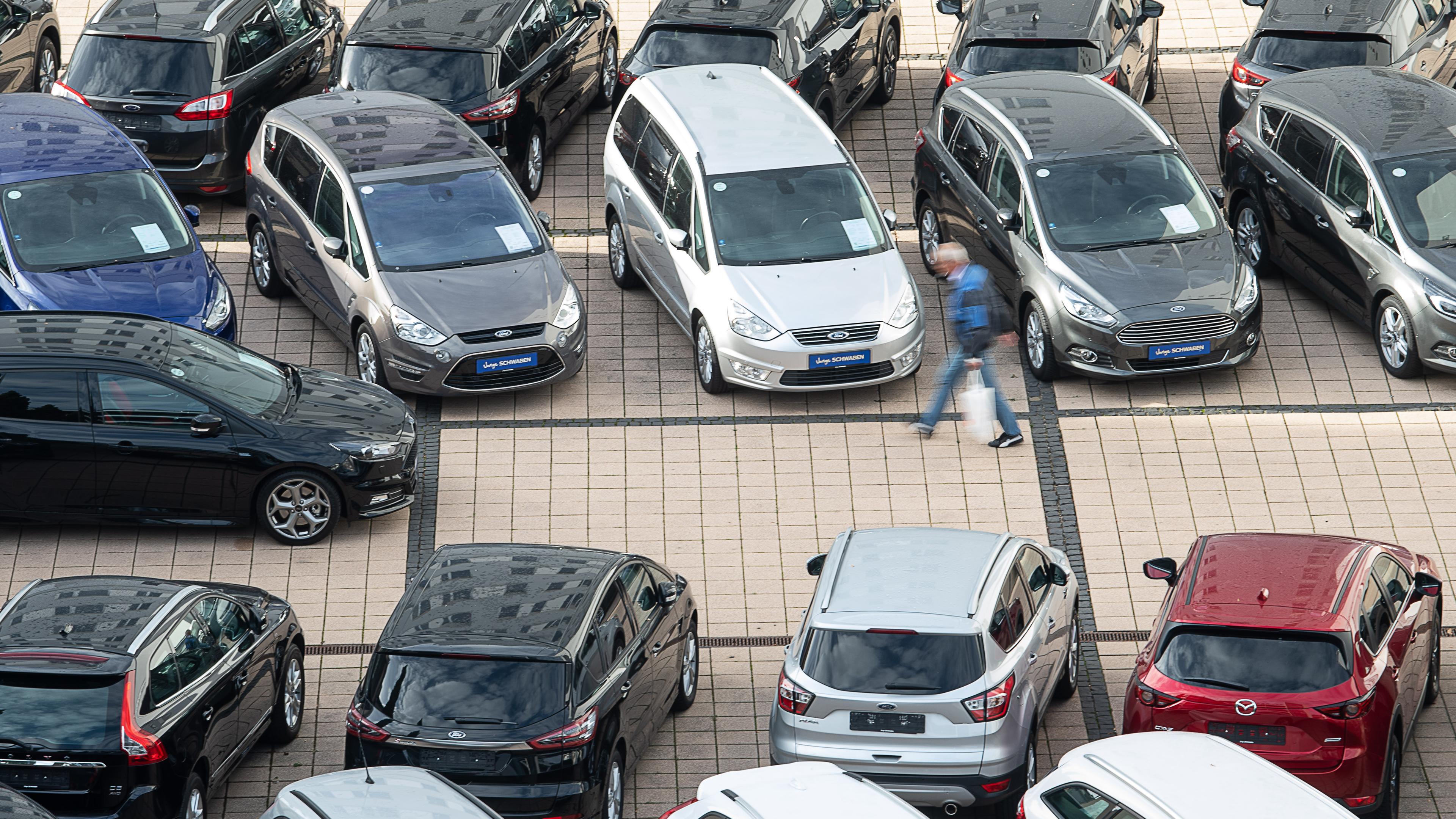  Baden-Württemberg, Stuttgart: Ein Mann geht in einem Autohaus an Gebrauchtwagen vorbei. Archivbild