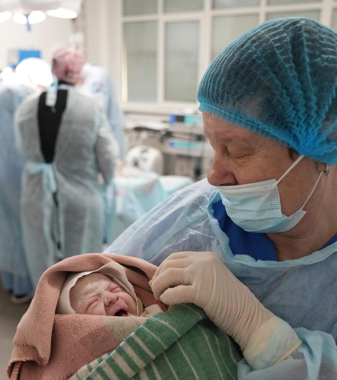 Eine Krankenschwester hält ein Neugeborenes in einem Krankenhaus in Mariupol in den Armen. 