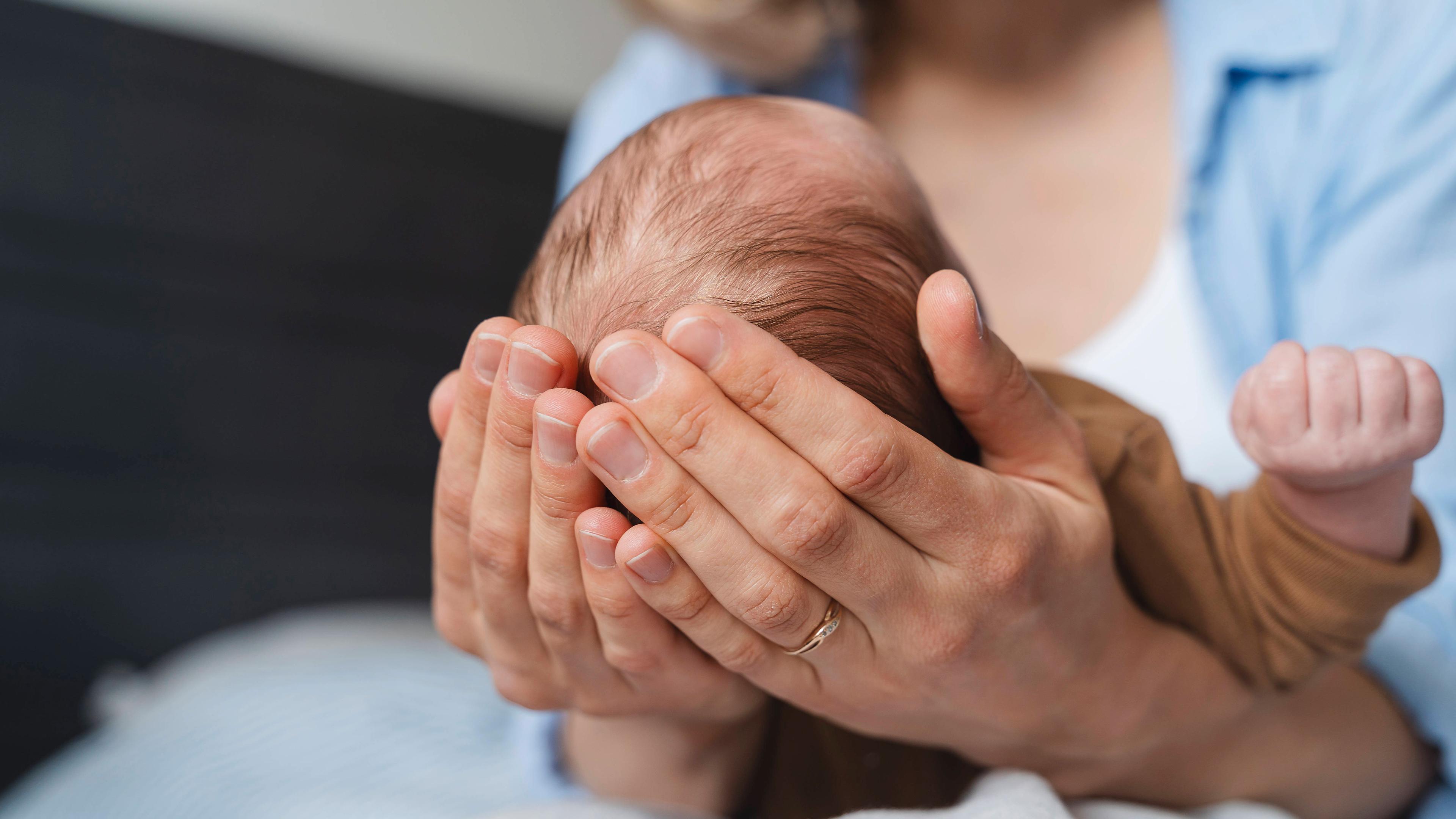 Eine Mutter hält ihren kleinen Jungen in den Händen