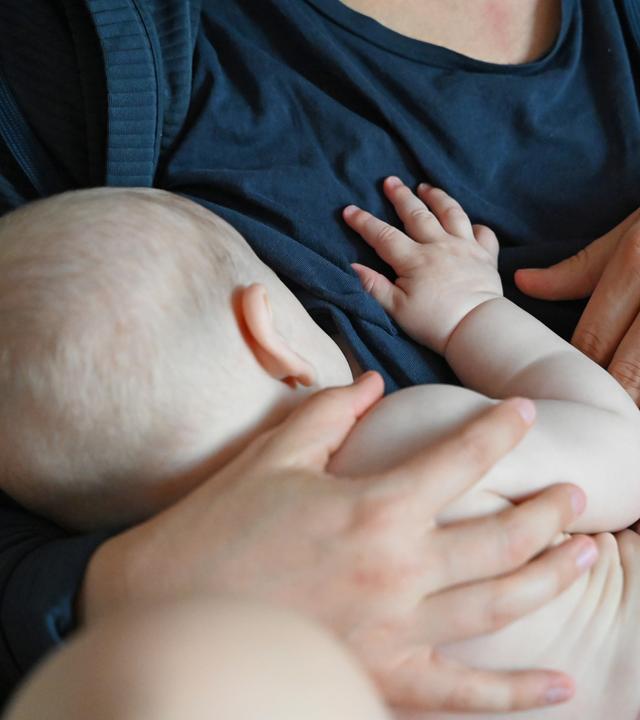 Eine Mutter stillt ihr Baby zu Hause. 