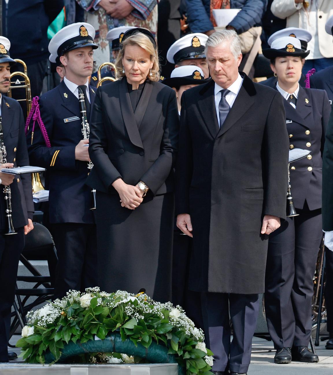 Belgiens König Philippe (M.r.) und Belgiens Königin Mathilde (M.l.), stehen schweigend nach der Kranzniederlegung während einer Gedenkveranstaltung zum 10. Jahrestag der Brüsseler Anschläge vom 22.03.2016 im Europaviertel