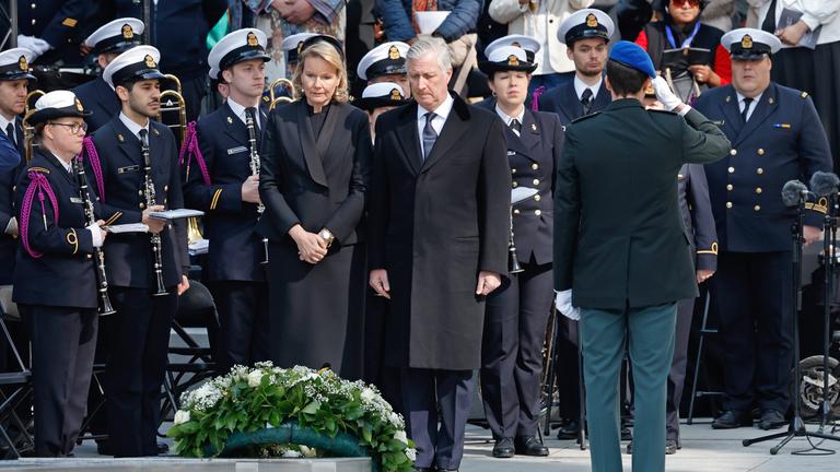 Belgiens König Philippe (M.r.) und Belgiens Königin Mathilde (M.l.), stehen schweigend nach der Kranzniederlegung während einer Gedenkveranstaltung zum 10. Jahrestag der Brüsseler Anschläge vom 22.03.2016 im Europaviertel