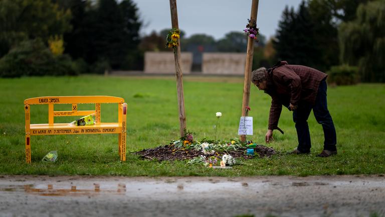 Ein Mann legt an einer Gedenkstätte für Enver Simsek, das erste Opfer der NSU, Blumen nieder. 