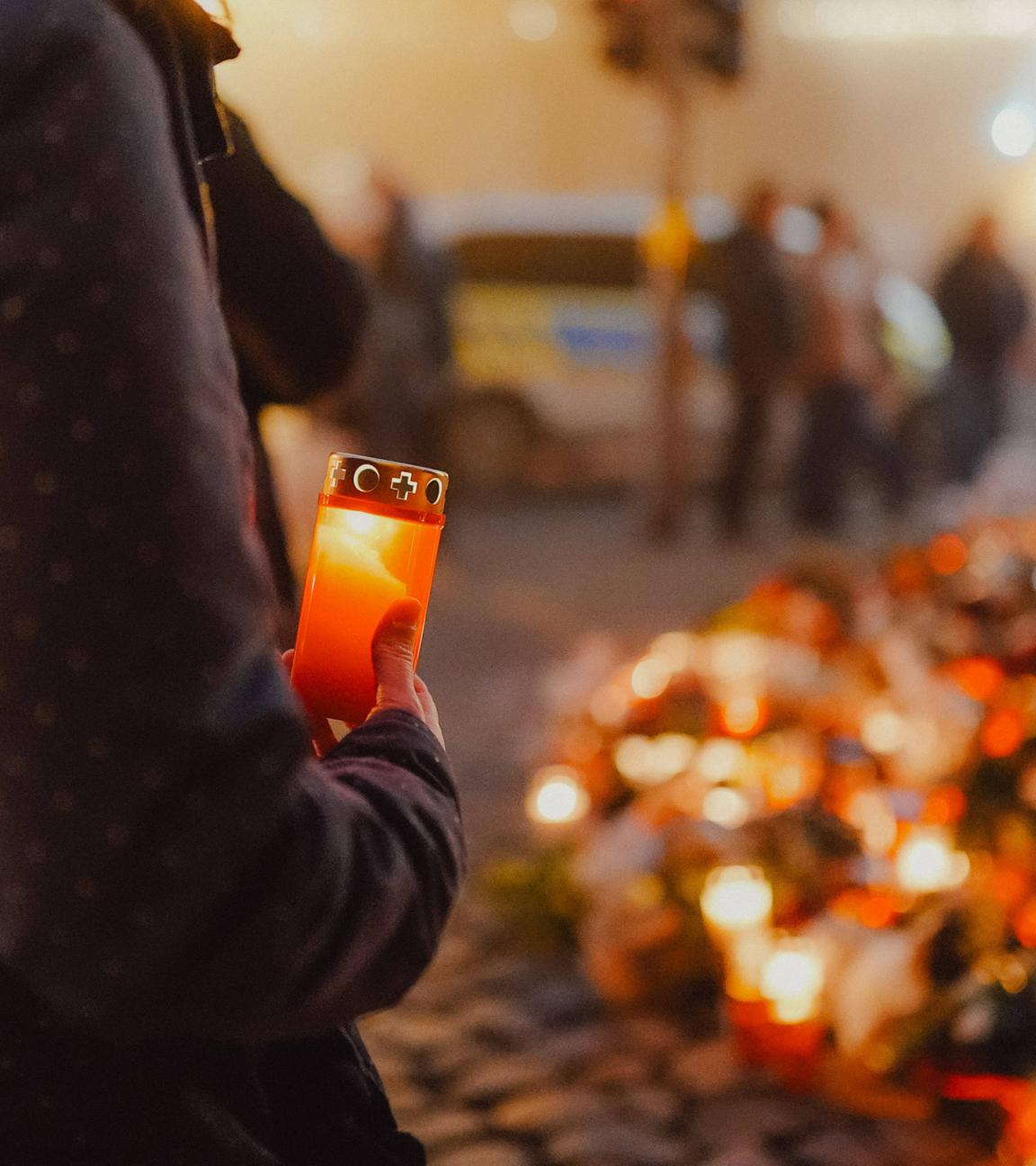 Archiv: Auch am 2. Weihnachtsfeiertag kommen weiterhin viele Menschen zur Johanniskirche um den Opfern zu gedenken, Das Blumenmeer wächst immer weiter, eine angeündete Kerze, Frau stellt eine Kerze zum Trauern auf, Anschlag auf den Magdeburger Weihnachtsmarkt, Sachsen-Anhalt, 20.12.2024