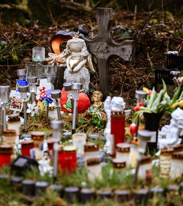 Archiv:  Kerzen, Blumen und Figuren liegen am Fundort an der Landesgrenze zwischen Rheinland-Pfalz und Nordrhein-Westfalen.