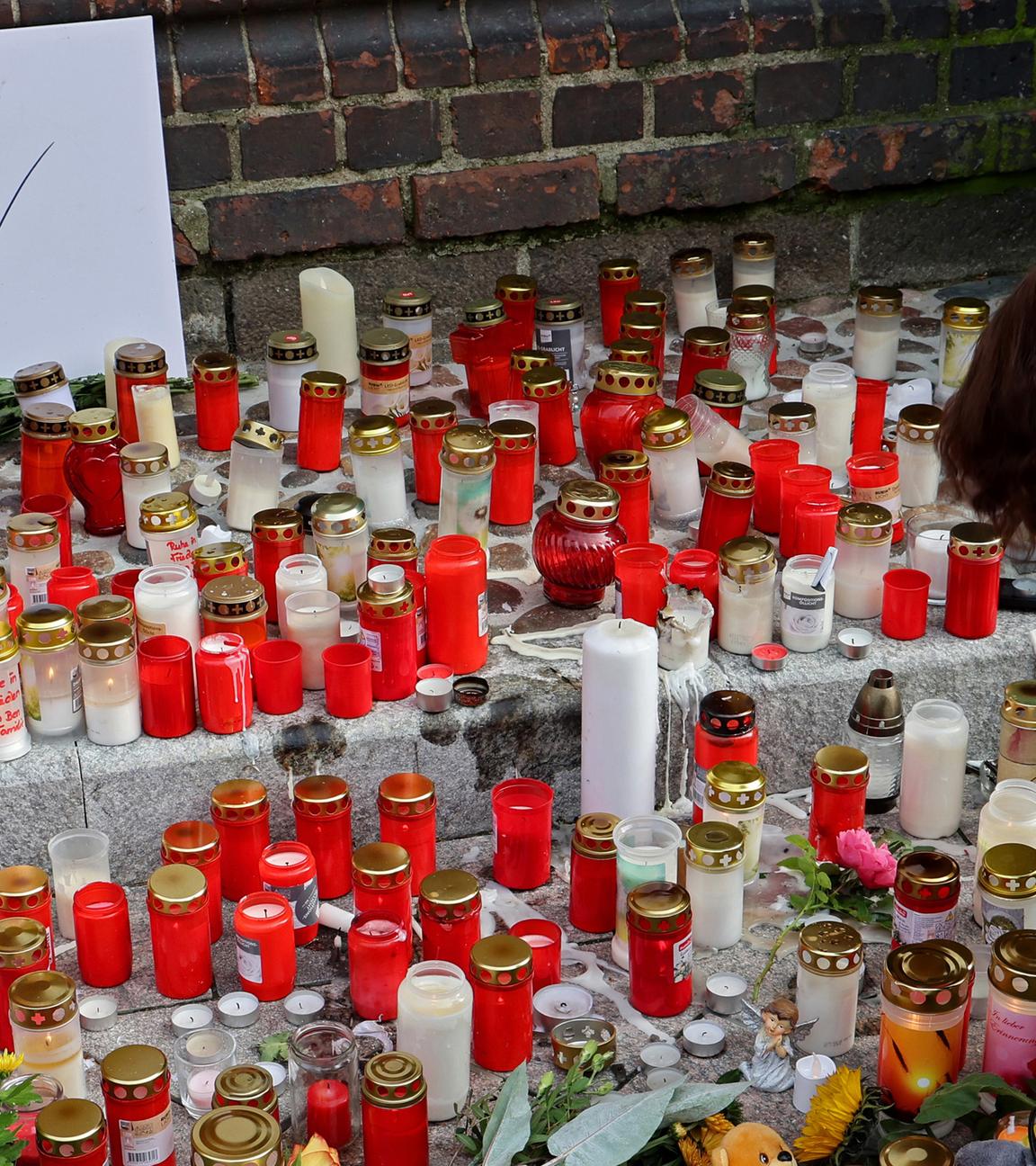 An der Marienkirche in Güstrow stehen Grablichter, Blumen und Plüschtiere im Gedenken an den vermissten achtjährigen Fabian, auf einem Schild steht "In Trauer um Fabian". 