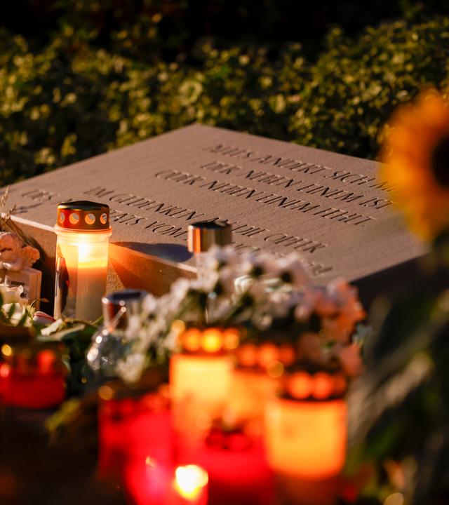 Nordrhein-Westfalen, Solingen: Weiße Rosen und Kerzen liegen am Gedenkstein für die Opfer des Terroranschlags von Solingen. Archivbild
