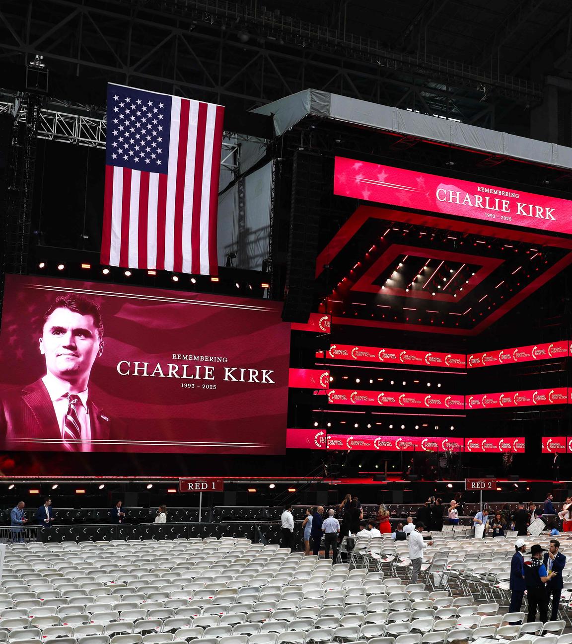 Die Halle für die Gedenkfeier. Eine große Bühne, Bilder von Charlie Kirk und Flaggen der USA