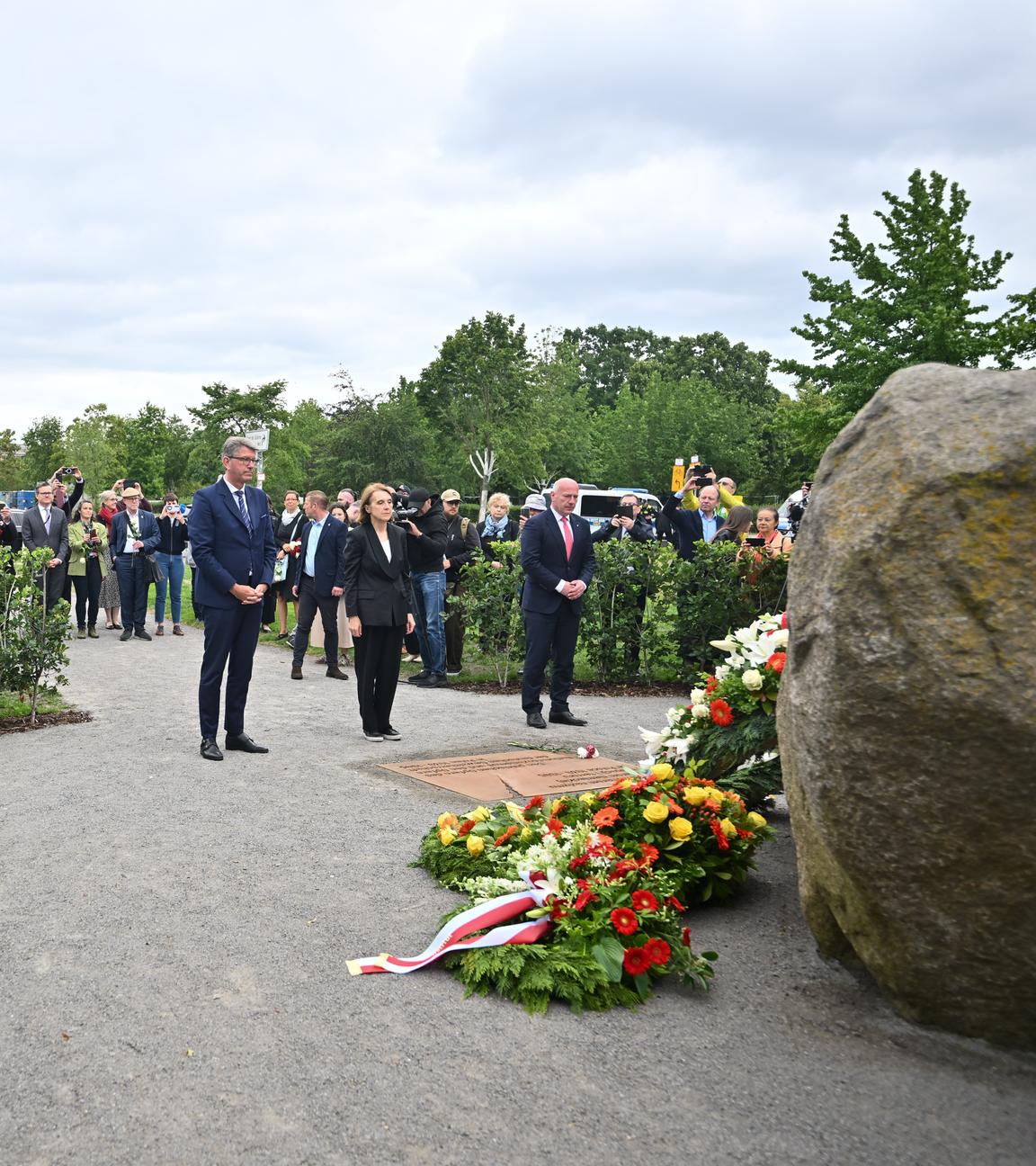 Deutsche Vertreter sowie Hanna Wroblewska, polnische Kulturministerin stehen während der Übergabe am Denkmal. im Hintergund ist deutsche Bundestag zu sehen.