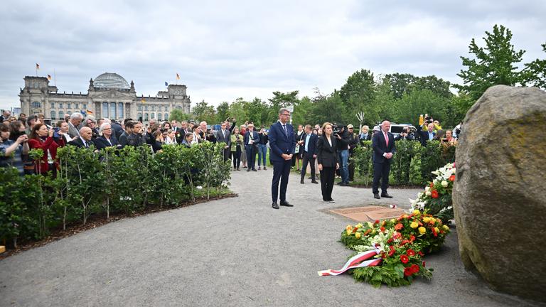 Deutsche Vertreter sowie Hanna Wroblewska, polnische Kulturministerin stehen während der Übergabe am Denkmal. im Hintergund ist deutsche Bundestag zu sehen.