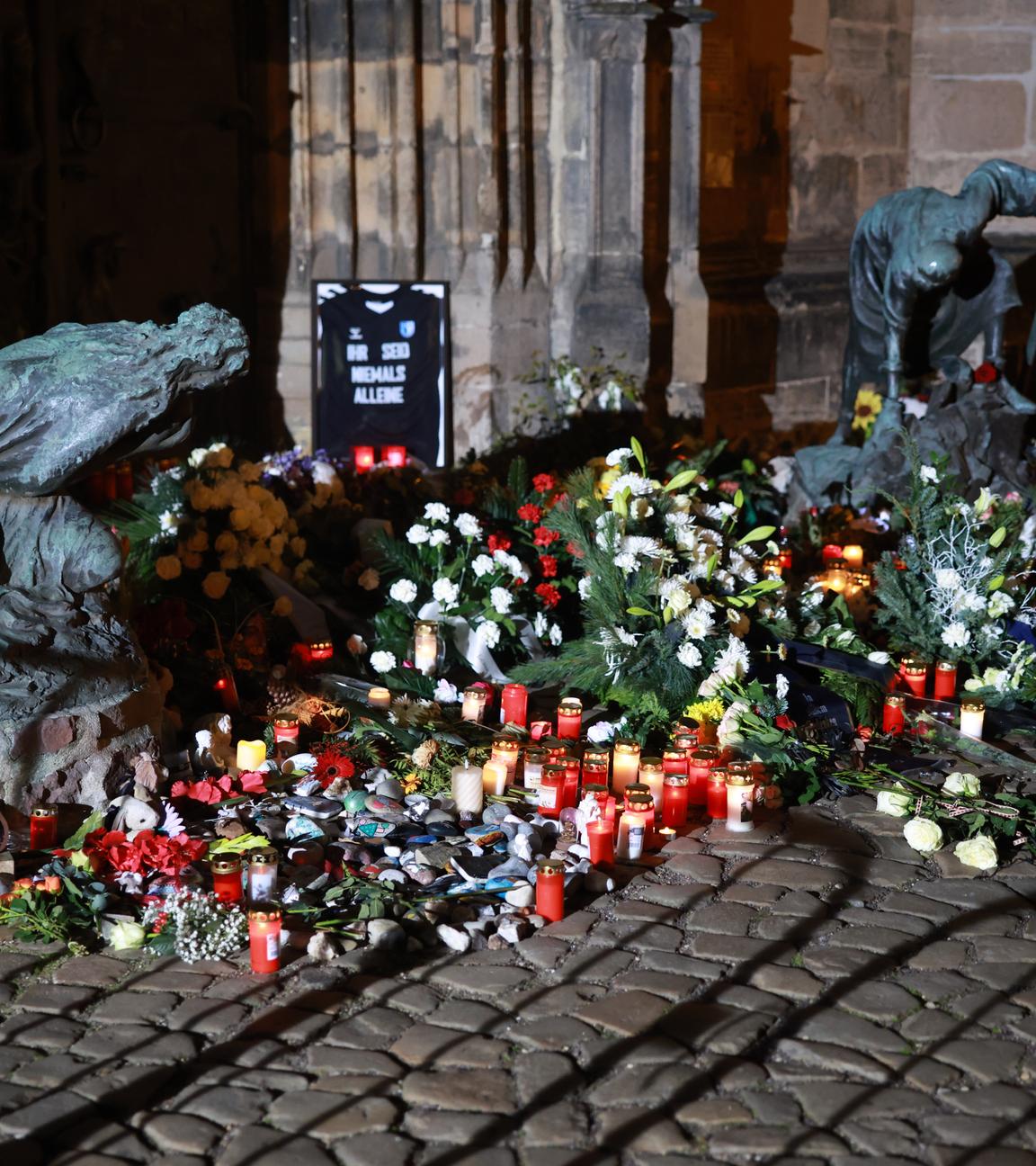 Vor der Johanneskirche in Magdeburg liegen Blumen und Kerzen.