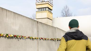 Die mit Rosen verzierte Mauer bei der zentralen Gedenkveranstaltung an der Gedenkstaette Berliner Mauer zum 35-jaehrigen Jubilaeum des Mauerfalls in Berlin