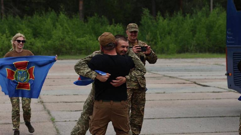 Zwei Menschen, die sich durch den Gefangenenaustausch wiedersehen und sich in die Arme fallen
