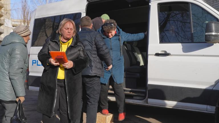 Ukrainer*innen steigen aus einem Bus am Grenzübergang 