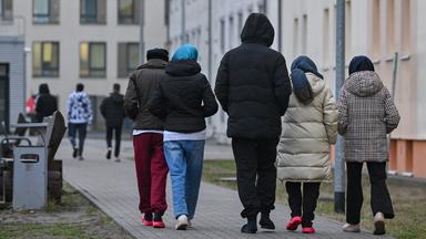  Migranten gehen über das Gelände der Zentralen Erstaufnahmeeinrichtung für Asylbewerber (ZABH) des Landes Brandenburg in Eisenhüttenstadt. (Archiv)