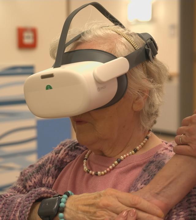 Eine ältere Frau mit einer VR-Brille.