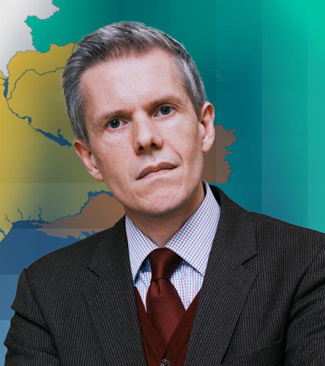 Militärökonom Marcus M. Keupp vor einer Karte der Ukraine und Russland.