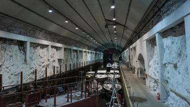 Ein länglicher Tunnel mit Wasser in der Mitte, darauf kleine Boote.