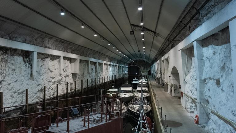 Ein länglicher Tunnel mit Wasser in der Mitte, darauf kleine Boote.