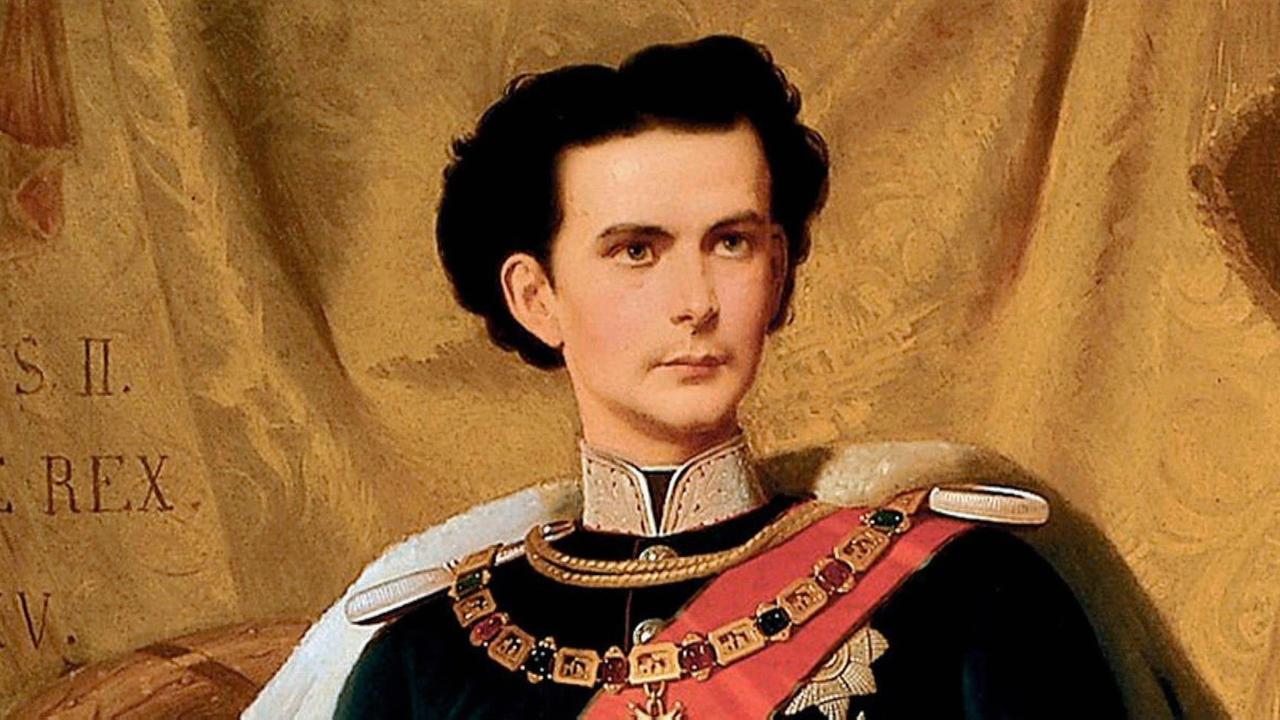 Ausschnitt eines Gemäldes. Abgebildet ist ein junger Mann mit dunklen Haaren und einer blau-roten Uniformjacke mit goldenem Kragen und goldenen Schulterstücken: Es ist ein Porträt von König Ludwig II..