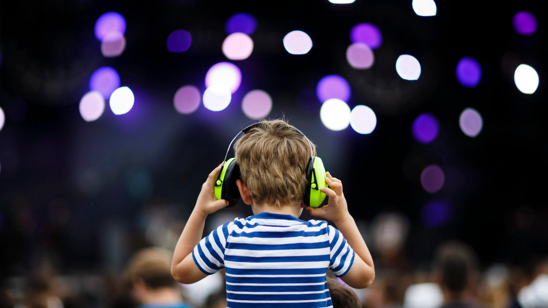 Ein Kind trägt auf einem Konzert Over-Ear-Kopfhörer.