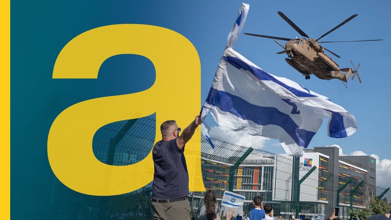 Isreali schwenken ihre Flagge während ein Helikopter mit freigelassenen Geiseln ankommt