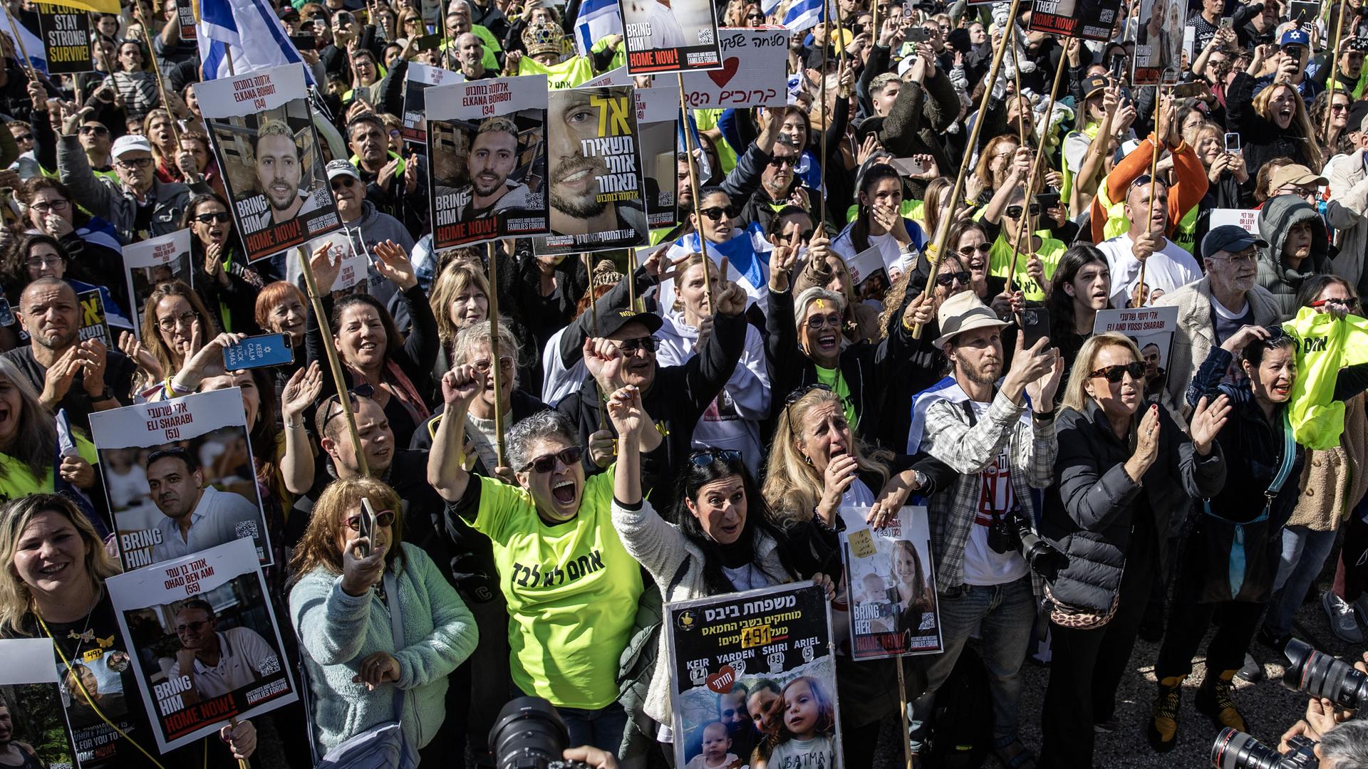 Israelis, die israelische Flaggen, Banner und Poster ihrer Verwandten tragen, versammeln sich auf dem Geiselplatz, um den Geiselaustausch zwischen der Hamas und Israel auf Großbildschirmen in Tel Aviv zu verfolgen