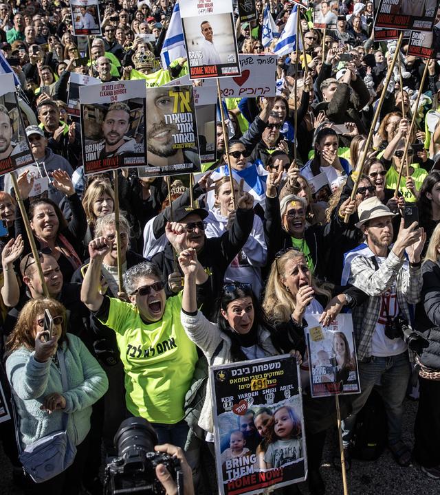 Israelis, die israelische Flaggen, Banner und Poster ihrer Verwandten tragen, versammeln sich auf dem Geiselplatz, um den Geiselaustausch zwischen der Hamas und Israel auf Großbildschirmen in Tel Aviv zu verfolgen