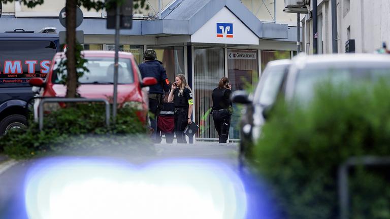 Bewaffnete Polizeibeamte sichern am 8. Mai 2026 das Gelände vor einer Volksbank-Filiale in Sinzig, Deutschland.