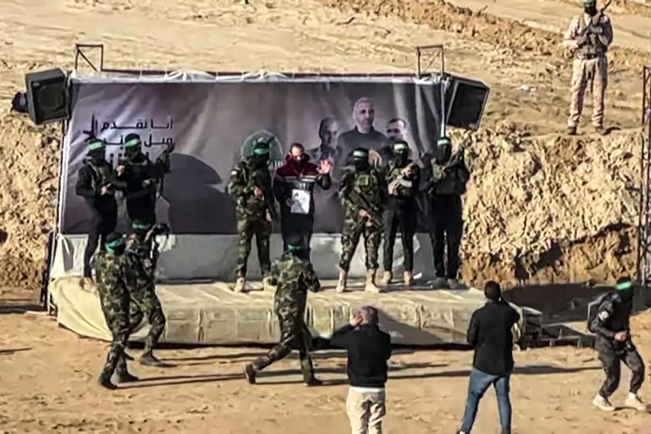  screen grab from an AFPTV footage shows Israeli hostage Yarden Bibas waving on a stage before being handed over to members of the International Red Cross