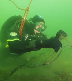Ein Taucher entfernt Geisternetze aus dem Meer