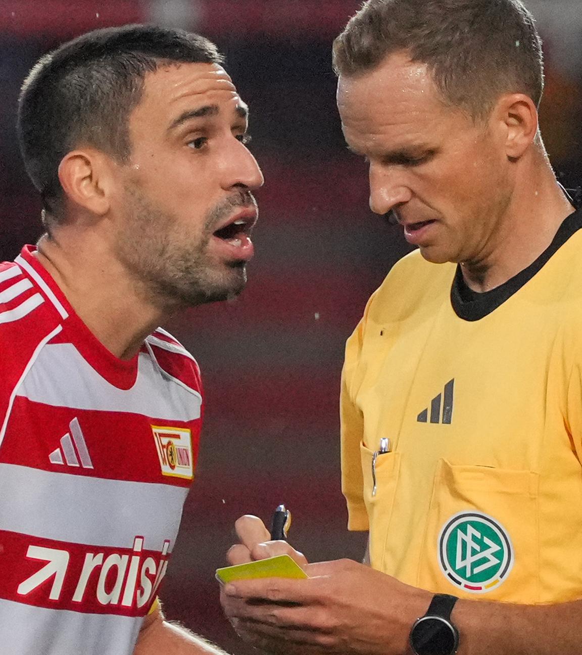 Rani Khedira (M, 1. FC Union Berlin) beschwert sich über eine Entscheidung von Schiedsrichter Sören Storks (r)