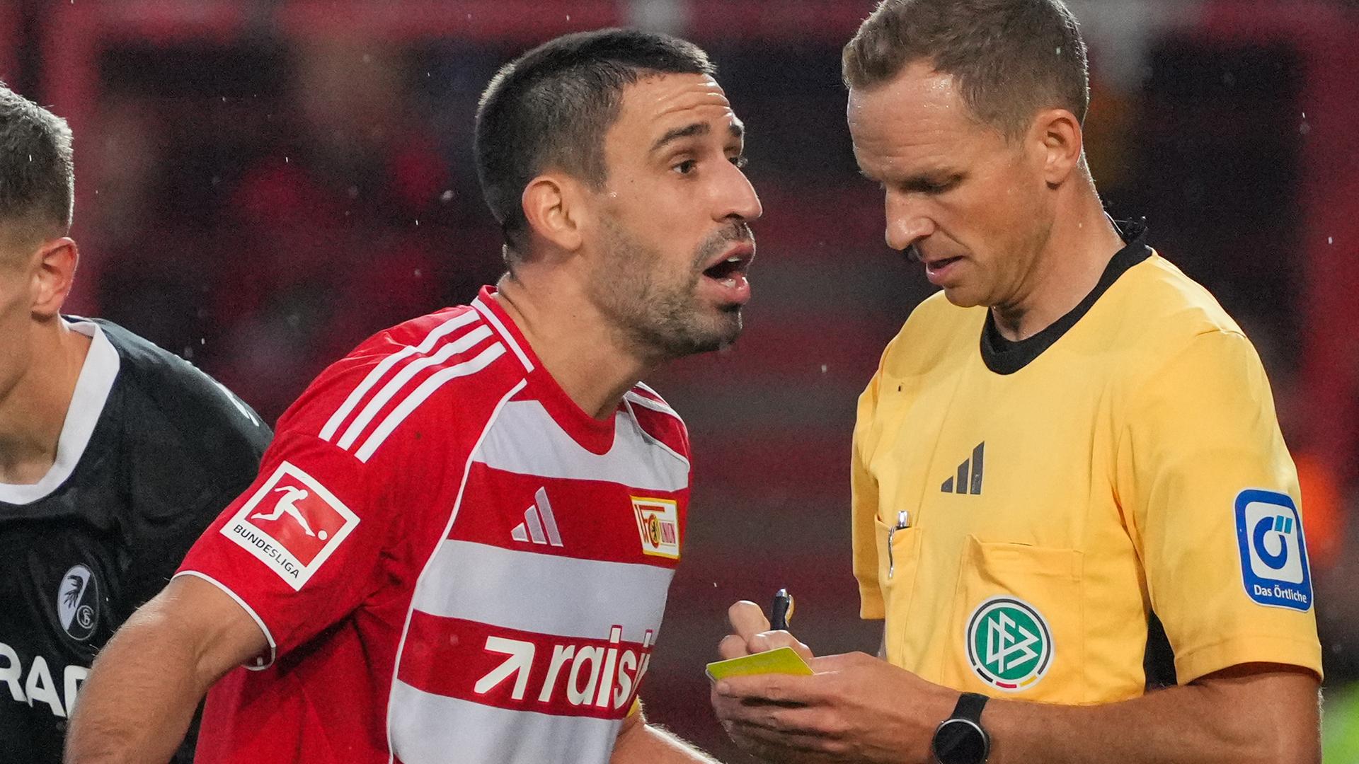 Rani Khedira (M, 1. FC Union Berlin) beschwert sich über eine Entscheidung von Schiedsrichter Sören Storks (r)