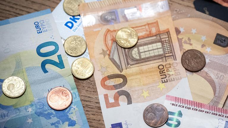 Geldscheine und Münzen liegen auf einem Tisch, aufgenommen am 14.11.2023